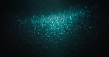 Blur glitter texture. Particles background. Bokeh light flare. Defocused blue green purple color sparkles flow on dark black abstract vertical overlay. Shot on RED Cinema camera.