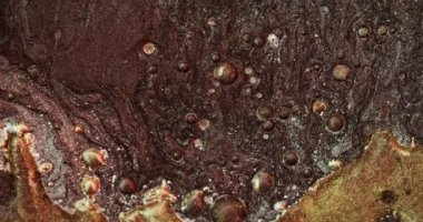 Glitter bubbles texture. Sparkling oil fluid. Glamour particles floating. Brown golden color sand grain motion in water abstract background. Shot on RED Cinema camera.