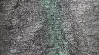 Vertical video. Shimmering background. Glitter noise. Shiny particles drip. Defocused black white green sparkling grain motion abstract texture. Shot on RED Cinema camera.