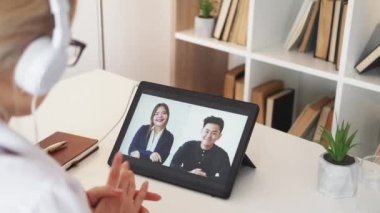 Online eğitim. Yabancı kurslar. Uzaktan görüşme. Kulaklıklı tanınmayan bir kadın aydınlatma odasının içindeki tablet bilgisayarda sanal konferans veriyor..