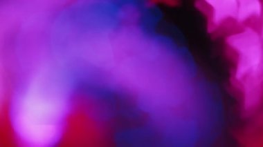 Bulanık neon parıltısı. Bokeh ışığı üstüste biniyor. Floresan yıldız dokusu. Koyu siyah soyut arkaplan üzerinde odaklanmış mavi pembe renk parıltı hareketi.