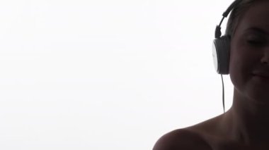 Kulağa hoş geliyor. Meditasyon müziği. Rahatlama ilhamı. Kulaklıklı mutlu bir kadının koyu yarı yüzü beyaz fotokopi arkaplanından izole edilmiş mp3 dinlemenin keyfini çıkarıyor..