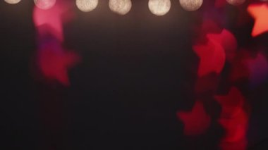 Işık süslemesi. Bokeh neon parıltısı. Şenlik çerçevesi. Yaprak süsü. Odaklanmamış kırmızı turuncu renkte sarı iplik aydınlatması koyu renk kopyalama arkaplanı.