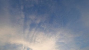 Gökyüzü açık. Hava cenneti. Huzur büyüsü. Açık mavi cennet, beyaz bulutlar, güneşli gün ışığında yavaş çekimde uçuyor..