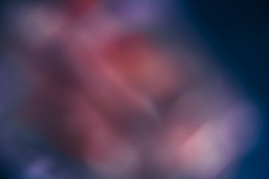 Bokeh meşalesi. Bulanık renk parıltısı. Pürüzsüz parıltı dokusu. Karanlık dekoratif soyut kopya alanı arka planında odaklanmış pembe parlaklık noktaları.