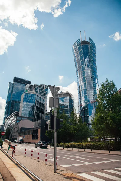 Varşova, Polonya - 22 Haziran 2022: Neomodern mimari. İş merkezi. Şehir merkezinde. Yüksek camlı binalı sokak yolu güneşli gün ışığında Varşova Spire.