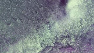 Dikey video. Parçacık arkaplanı. Parlak doku. Işıldayan sıvı akışı. Dijital lavanta mor beyaz renkli, soyut, parlak tahıl yüzeyi giriş için. RED Sinema Kamerasında Çekim.