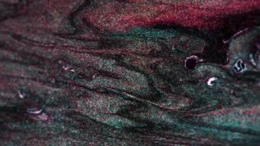 Dikey video. Köpüklü sıvı karışımı. Parlak doku. Parıldayan dalga. Kırmızı yeşil renkli parlak parçacıklar holografik olarak soyut arkaplanda akarlar. RED Sinema Kamerasında Çekim.