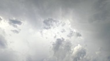 Bulutlu gökyüzü. Hayali bir atmosfer. Doğa güzelliği. Açık gri tüylü bulutlar cenneti güneş ışınlarıyla kaplıyor. Işıklar yavaş çekimde uçuyor..