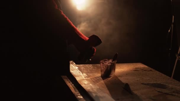 수공품 수없는 작업꾼 프라이머를 사용하여 어두운 작업장에서 톱밥으로 작업을 마무리 — 비디오