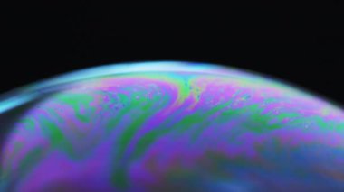 Sabun köpükleri. Kimyasal sanat. Macro vuruldu. Gökkuşağı desenli şeffaf akışkan ampul siyah zigzaglar üzerinde neon açık mor yeşil zigzaglar yüzüyor.