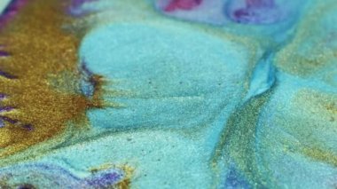 Mixing colors. Fluid magic. Creative painting. Cyan blue purple gold stream of liquid paint floating. Marble effect
