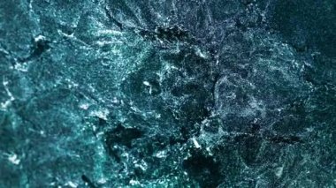 Dikey video. Parıltılı akışkan hareket. Parıldayan su. Okyanus dalgası köpüğü. Teal yeşili mavi beyaz renk parlak sıvı soyut doku arkaplanı. RED Sinema Kamerasında Çekim.