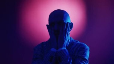 Suç farkındalığı. Panik adam. Şok edici bir durum. Endişeli, takım elbiseli, elleri olan, parlak mavi arka planda korkan, elleri titreyen adam..