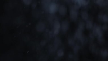 Gece kar yağıyor. Bokeh ışığı. Kar fırtınası örtüşüyor. Kış fırtınası. Giriş için koyu siyah soyut arkaplan efekti üzerinde odaklanmış beyaz parçacıklar hareketi.