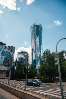 Varşova, Polonya - 22 Haziran 2022: Tarihi eser mimarisi. İş merkezi. Neomodern stil. Yüksek camlı binalı sokak yolu güneşli gün ışığında Varşova Spire.