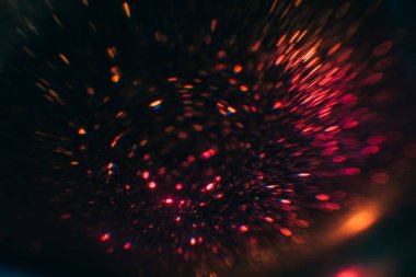 Kırmızı bulanık peri ışıkları. Karman çorman parlak lekeler. Koyu soyut arkaplan.