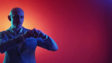 Satış promosyonu. Etkileyici bir adam. Neon ışıklı portre. Kırmızı sarı arkaplanda uzayı kopyalamak için sihirli jest yapan yakışıklı adam..