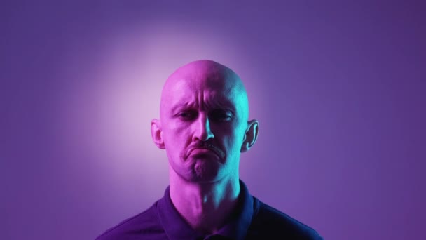犯罪者だ 子供の表情 顔は紫のネオンライトの背景を示すばかばかしい男巻き口 — ストック動画