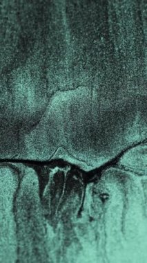 Vertical video. Glitter fluid flow. Sparkling particles texture. Shimmering wave. Verdigris green black color shiny marble abstract background. Shot on RED Cinema camera.