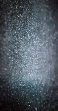 Parçacık arkaplanı. Bokeh meşalesi. Çemberler parlıyor. Siyah soyut dokular üzerinde sönük beyaz kıvılcımlar yüzüyor. Dikey video. RED Sinema Kamerasında Çekim.