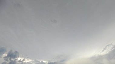 Gün batımı gökyüzü. Hayali bir atmosfer. Doğa güzelliği. Açık gri yoğun bulutlar cenneti güneş ışınlarıyla kaplıyor..