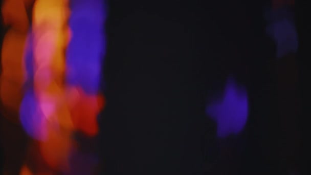 ネオンボケの光 ぼかしの色オーバーレイ 星模様の装飾 濃い黒の抽象的な背景のオレンジ色の青の光の動きを強調 — ストック動画