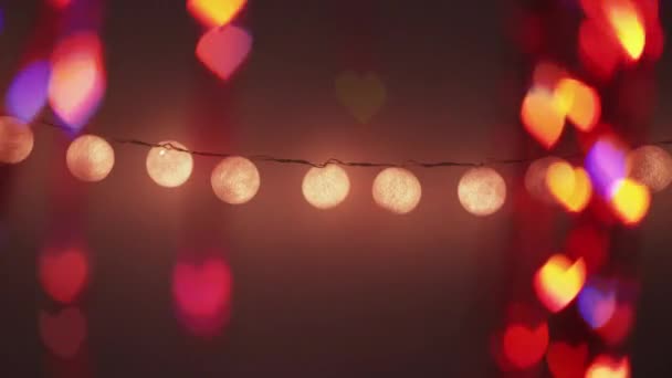 로맨틱 보케의 발렌타인데이 디자인 전구는 오렌지색의 물질로 흐릿하게 보이게 어두운 — 비디오