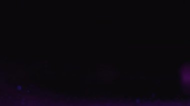 Neon geçiş kaplaması. Renk dumanı. Parlak yağmur. Odaklanmamış floresan mor sis bulutu, parlak ışık çemberleri karanlık karanlık gece soyut arka planında hareket ediyor..