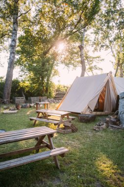 Kırsal kamp. Doğa rahatlar. Meyve bahçesi işleri. Güneşli bahçede piknik alanı olan rahat bir çadır..
