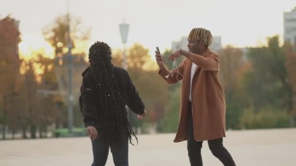 浪漫的约会愉快的散步 快乐的时刻快乐的黑人男人在智能手机上给心爱的女人拍照在街上慢动作 — 图库视频影像