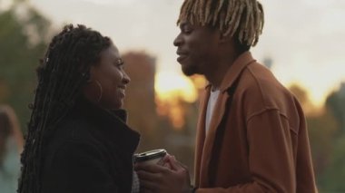 Romantik bir randevu. Sevgili çift. Memnun oldum. Mutlu siyah adam caddede sevilen kadına doğru yürüyor. Ellerine sarılmış bir fincan kahveyle ağır çekimde..