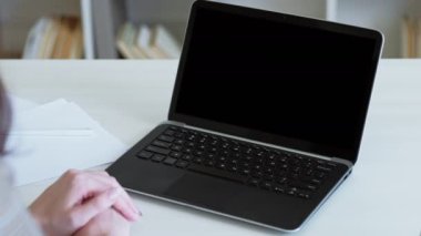 Boş ekran. Sanal öğrenme. Uzaktan eğitim. Bilgisayarda boş bir fotokopi siyah ekranıyla online ders izleyen tanınmayan bir kadın. Uzun video çekimi.