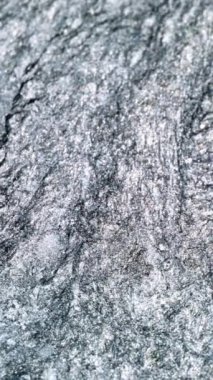 Dikey video. Buz soyut arka plan. Buz kristalleri. Odaklanmamış tek renkli açık renkli beyaz gri simli mürekkep suda düz tahıl yüzeyi ile akıyor. RED Sinema Kamerasında Çekim.