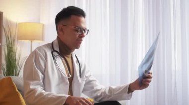 Doktor molası. Gezici oyun eğlencesi. Sanal eğlence. Dikkatsiz pratisyen adam X-ray filmini fırlatıp atıyor. Evdeki dahili akıllı telefondan oynuyor..