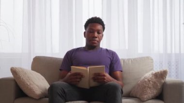 Ev tatili. Sıcak bir hafta sonu. Yorgunluk okuyorum. Rahat, yorgun bir adam, açık bir kitapla uyukluyor. Açık oturma odasının iç tarafında boş yer var..