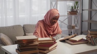 Yorgun bir eğitim. Uykulu kadın. Sınav hazırlığı. Başörtüsü içindeki yorgun bayan notlar alıyor. Işıklandırma odasındaki kitaplarla ders çalışıyor..