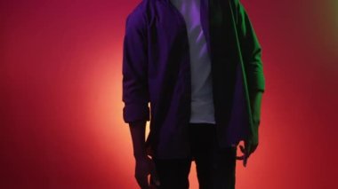 Neon dansçısı. Parti serinliği. Pozitif enerji. Tanımlanamayan rahat adam kırmızı turuncu renk gradyan fotokopi arkaplanda dans ediyor..