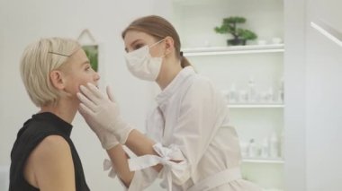 Güzellik prosedürü. Kadın konsültasyonu. Profesyonel tedavi. Kozmetik uzmanı tarafından incelenen orta yaşlı güzel bir kadın..