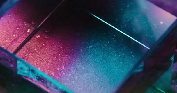 ガラスキューブの回転 蛍光色の背景 ネオンピンクブルーの輝きエッジ角度トレンド未来的なサイバーパンク抽象的なテクスチャを強調 Redシネマカメラで撮影 — ストック動画