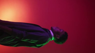 Dikey video. İyi seçim. İnsanların reklamını yapmak. Metin için kırmızı renk gradyan kopya arkaplanı üzerinde iyi bir jest yaparak tatmin olmuş bir adamın neon ışıklı profil portresi.