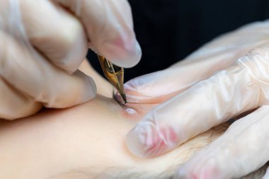 Kirpiklerin kalıcı dövmesini yapan dövme makinesinin iğnesinin makro fotoğrafçılığı