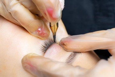 Yüzyılın makine teknolojisi modelinin kalıcı makyajı. Usta bir dövme yapıyor.