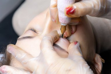 Modelin üst göz kapağına dövme yapma işlemi