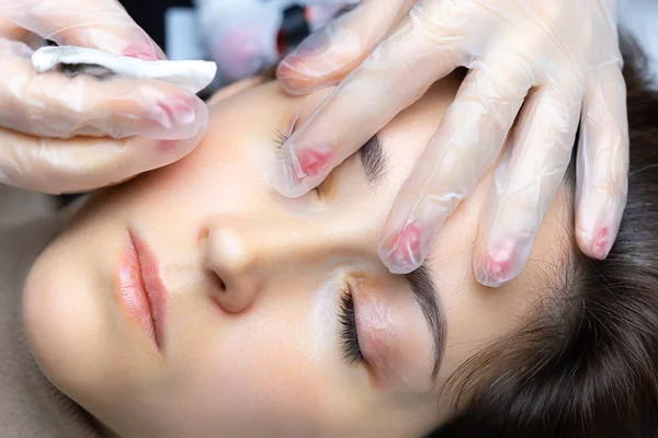 Modelin yüzündeki fazlalık pigmentleri ters süngerle temizliyor.