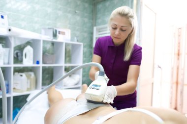 Şu anda süpürge masaj makinesinin kapağını kapatıyoruz. Beyaz iç çamaşırlarıyla kanepede uzanan mankenin kalçaları üzerinde çalışıyoruz.