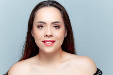 Güzel esmer model kameraya bakıyor ve gülümsüyor.