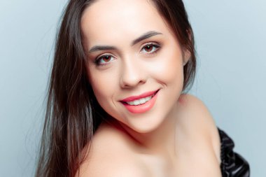 Güzel esmer model kameraya bakıyor ve gülümsüyor.