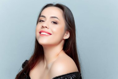 Güzel esmer model kameraya bakıyor ve gülümsüyor.