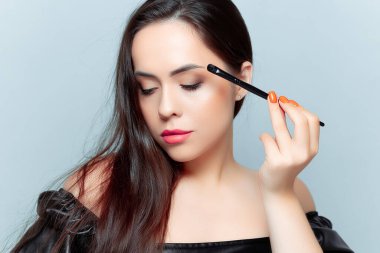 Genç esmer makyaj ve fırça yapar.